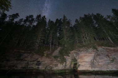 Estonya manzarası, gece manzarası, Ahja nehri ve mağarasının dik kumtaşı kıyısı, yıldızlı gökyüzü..