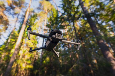 Ormanda uçmakta olan yüksek kalite kameralı bir kuadkopter drone.. 