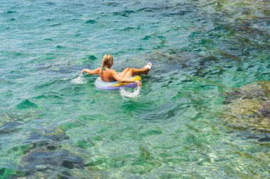 Akdeniz 'de bir yaz günü Fransa' nın güneyinde şişme kauçuk bir halkada yüzen bir kadın..