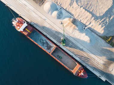 Deniz taşımacılığı, kuru kargo gemisi bölmesi bir yaz akşamı Muuga limanında ezilmiş taşla doldurulur.. 