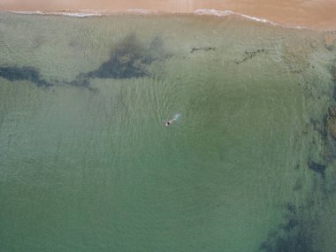 Bir kadın yüzücü, Portekiz 'de bir plajın yakınında Atlantik Okyanusu' nda yüzer.. 