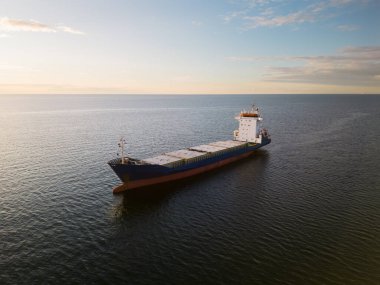 Kargo gemisi gün batımında Finlandiya Körfezi 'nde (Baltık Denizi) denize açılır..