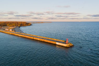 Paljassaare üzerinde şafak: düşük kar yağışında deniz feneri ve dalgakıran manzarası. 