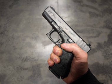 Baltık Devletleri, 22 Ocak 2024. Bir adamın elinde beton zemine dayalı 9mm Avusturya Glock 19 tabancası.. 