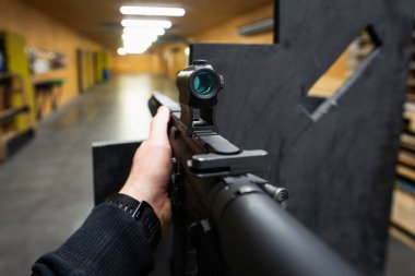 Atış poligonundaki bir hedefe kırmızı noktalı tüfekle nişan almak. Fotoğraf birinci şahıs görüşünden..