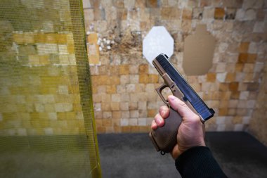 Baltık, 24 Ocak 2025. Kamuflaj renginde taktiksel bir Glock 17 tabancası eğitim sırasında atış poligonunda bir nişancının elinde..