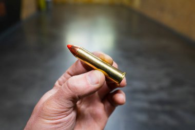 A very powerful cartridge from a Magnum revolver of 45x70 government caliber in a man's hand. clipart