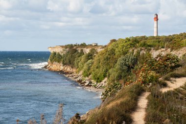 Stormy waves of the Baltic Sea at the foot of the picturesque cliff of Pakri Peninsula, Paldiski, Estonia. clipart