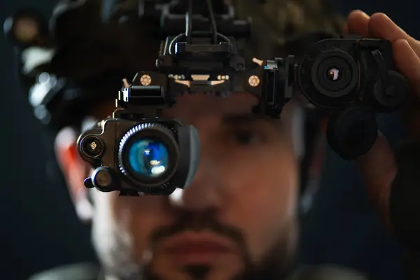 - Tabii ki! İşte başlığın çevirisi: Askeri teknoloji: yüksek teknolojili gece görüşü cihazı olan bir askerin yakın çekimi bir kaskın üzerine monte edilmiş bir termal görüntüleyici ile eşleştiriliyor. Yumuşak odaklı fotoğraf.