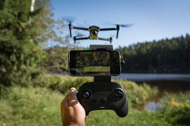 Akıllı telefonlu bir İHA 'yı kontrol etmek: birinci şahıs görüntüsü, pitoresk bir göl üzerinde uçmak.