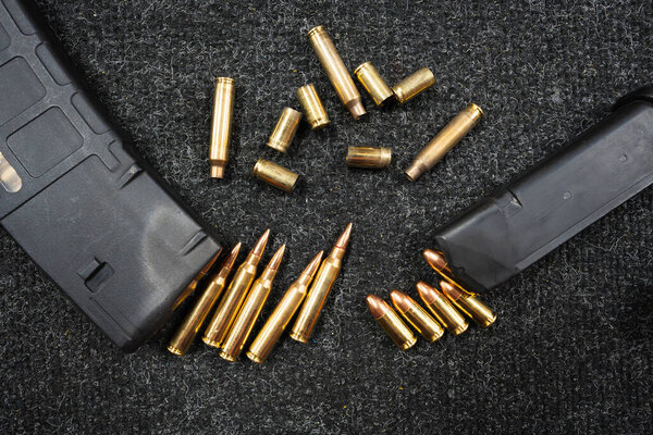 Pistol and rifle magazines with cartridges and shells, close-up photo.