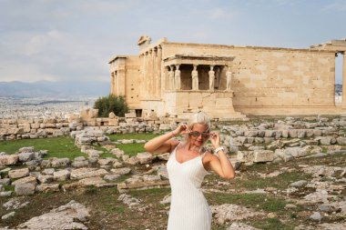 Güneş gözlüklü güzel sarışın turist kız antik Atina 'da Parthenon' u ziyaret ediyor..