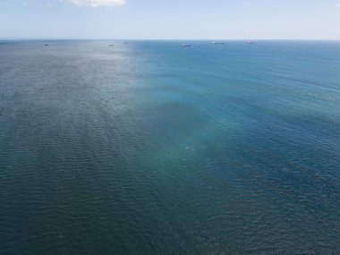 Ufukta kargo gemileri ve görünür bir haloklinle okyanus manzarası..