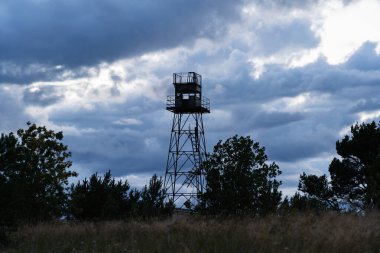 Fırtınalı gökyüzüne karşı eski Sovyet gözlem kulesi. Terk edilmiş bölge, gerilim ve endişe ortamı.