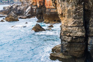 Atlantik Okyanusu 'nun çalkantılı dalgaları tarafından günbatımında Portekiz' in pitoresk kıyı manzarasında sürüklenen engebeli uçurumlar..