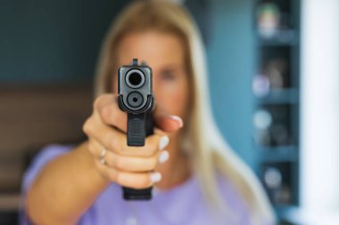 Elinde silah olan bir kız, odaklanmamış bir fotoğraf, odakta silah..