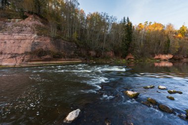 Resimli sonbahar manzarası: Gauja nehri, kumtaşı bankaları ve akıntılar.