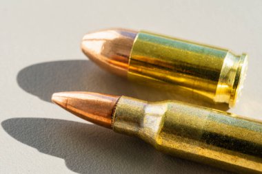 Tüfek 5.56x45mm ve 9mm tabanca fişeği, makro fotoğraf.