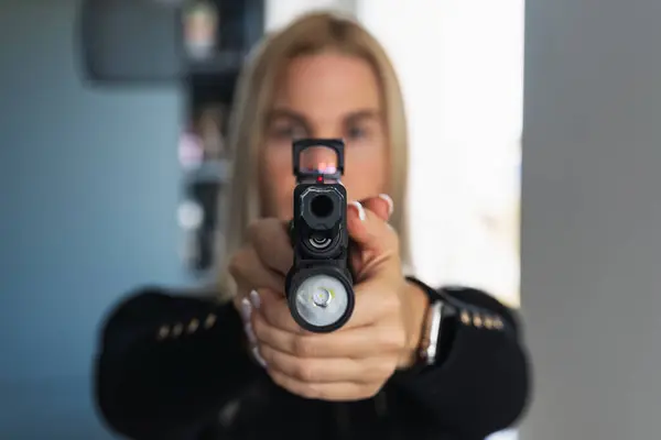 Entrika, evinizi korumakla ilgili. El fenerli taktik bir tabanca ve kızın ellerinde kırmızı bir noktalı görüş..