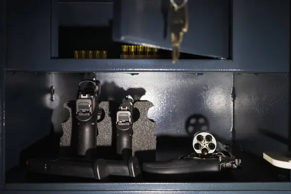 Tabancalar, tabanca ve el feneriyle aydınlatılmış bir silah kasasında mühimmat..