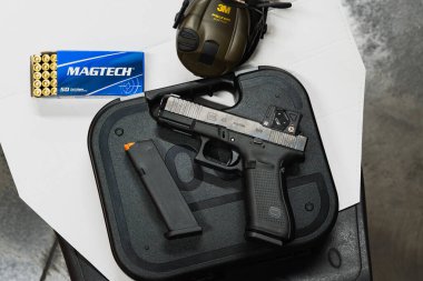 22 Mart 2025, Baltık: Yeni Glock 45 MOS tabancası Aimpoint COA görüşü, Magtech 9x19 mühimmatı, Peltor kulak koruması ve atış menzilinde bir hedef.