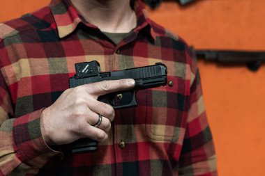 Baltık, 22 Mart 2025. Sivil bir nişancının elinde Glock 45 tabancası var. Elinde de Aimpoint COA kırmızı nokta görüşü var..
