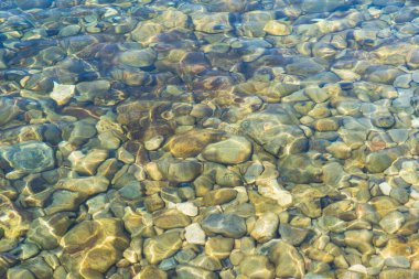Çakıl taşlı temiz nehir suyu: doğal arka plan, alt doku, yaz havası, üst manzara.
