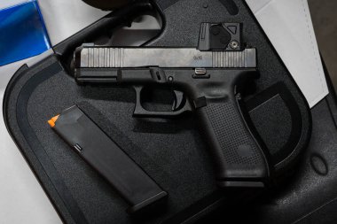 Atış poligonunda kırmızı nokta görüşlü modern 9mm plastik çerçeve tabancası..