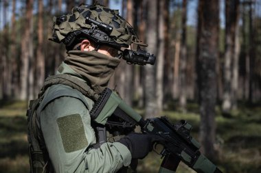 Asker, taktik teçhizat ve miğfer takıyor..