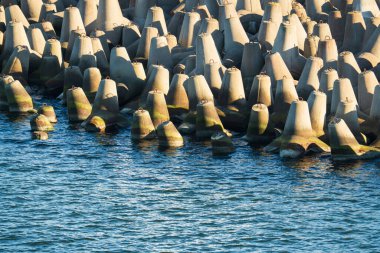 Beton kırıcı su tetrapodları kıyı şeridini güneşli bir günde deniz dalgalarından ve aşınmadan korur..