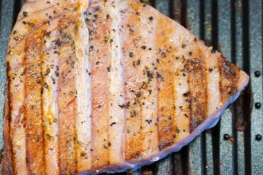 Izgarada ızgara yapan baharatlı ton balıklı bifteğin yakın çekimi..