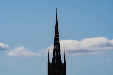 Stockholm 'de bulutlu mavi gökyüzüne yükselen uzun Gotik kilisesinin silueti..