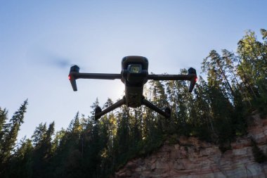 Estonya Tartu County 1 Eylül 2024. DJI Mavic 3 Klasik İHA ormanda uçuyor.
