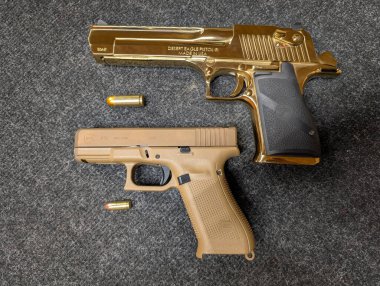 Baltık, 14 Nisan 2025. Kalibrelik kontrast: standart bir 9mm Glock 19X 50 AE Çöl Kartalı ve mühimmatlarının yanında..