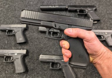 Baltık, 15 Nisan 2025: Siyah Glock 21 .45 otomatik tabanca yakın plan, ateşli silah koleksiyonu arka planda bulanık.