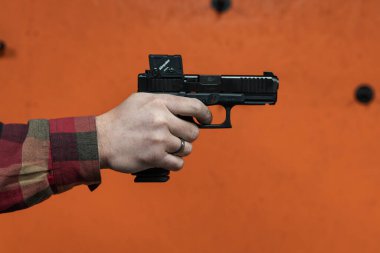 Baltık, 24 Şubat 2025 Yakın çekim: ateşli silah yeterlilik eğitimi sırasında 45 Glock COA tabancası el tutmaktadır. Yüksek kalite fotoğraf.