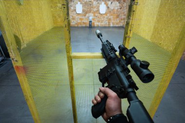 Birinci şahıs görüş: nişancı, optik görüşlü ve kapalı alandaki hedeflere susturuculu bir taktik tüfeği hedef alıyor..