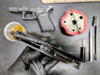 Profesyonel ateşli silah bakımı ve temizliği: kapsamlı bakım ve yağlama için bir tabancanın sökülmesi.