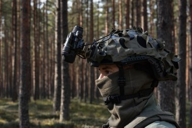 Gece görüş gözlükleri de dahil olmak üzere tam teçhizatlı bir askerin profili devriye sırasında veya ormanda eğitim görürken dikkatli ve tetikte..