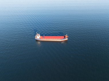 Güneşli bir günde Baltık Denizi 'nin sakin sularında yelken açan büyük bir kargo gemisinin hava fotoğrafları..