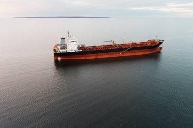 Açık denizde büyük bir petrol tankeri: bulutlu bir gökyüzünün altında sakin su üzerinde bir kargo gemisinin havadan çekimi.