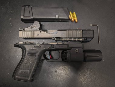 Baltık 15 Mayıs 2025. Telafi edici, kırmızı nokta görüşlü ve el fenerli özel Glock 19 tabancası..
