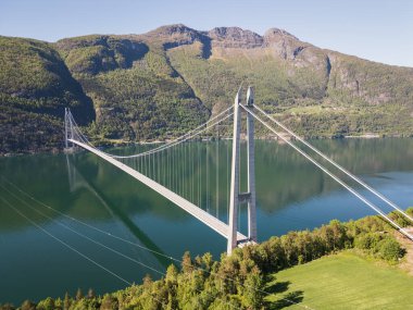 Norveç, Hardanger Köprüsü: Dağların ortasındaki fjord üzerinde yükselen modern bir mühendislik harikasının insansız hava aracı görüntüsü.