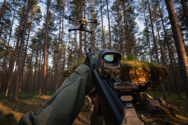 Drone Savaş Karşıtı: Bir saldırı tüfeği ve taktiksel görüşü olan bir avcı uçağı ormanda bir İHA 'yı fark etti..