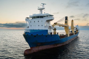 Gün batımında Baltık Denizi 'nde deniz kargo gemisi, hava aracı manzaralı. Nakliye gemisi, denizcilik, endüstriyel deniz manzarası..