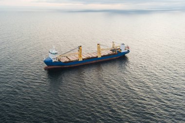 Estonya açıklarında Baltık Denizi 'nde kargo gemisi, hava manzaralı. Arkaplanı durgun su ve bulutlu gökyüzü olan deniz taşımacılığı.