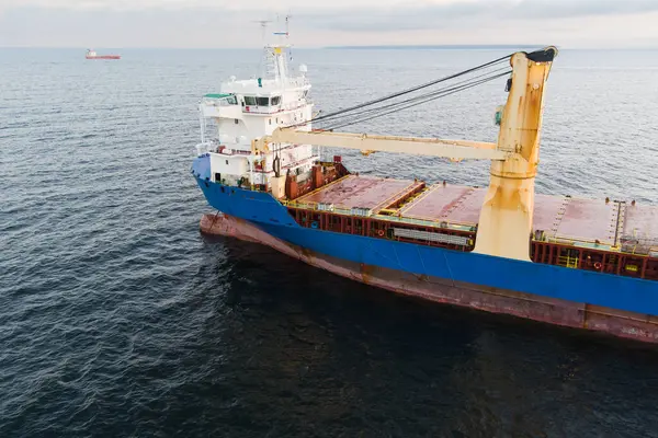 Baltık Denizi 'ndeki bir kargo gemisinin detaylı drone görüntüsü: Mavi gövde, güverte, güçlü vinçler; ufukta başka bir gemi. 