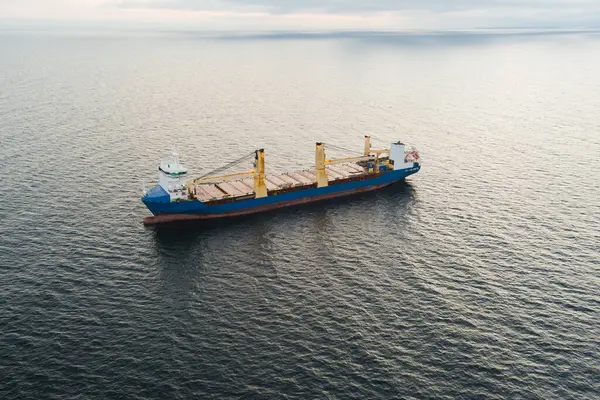 Estonya açıklarında Baltık Denizi 'nde kargo gemisi, hava manzaralı. Arkaplanı durgun su ve bulutlu gökyüzü olan deniz taşımacılığı.