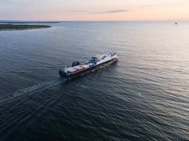 Gün batımında Estonya açıklarında Baltık Denizi 'nden geçen Ro-Ro feribotu ve yarı römorkları gösteren bir hava aracı görüntüsü..