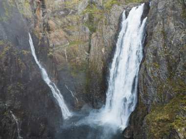 Norveç 'teki güçlü Voringsfossen şelalesinin nefes kesici drone görüntüsü, görkemli kayalık kanyonun ve akan suyun havadan görüntüsü..